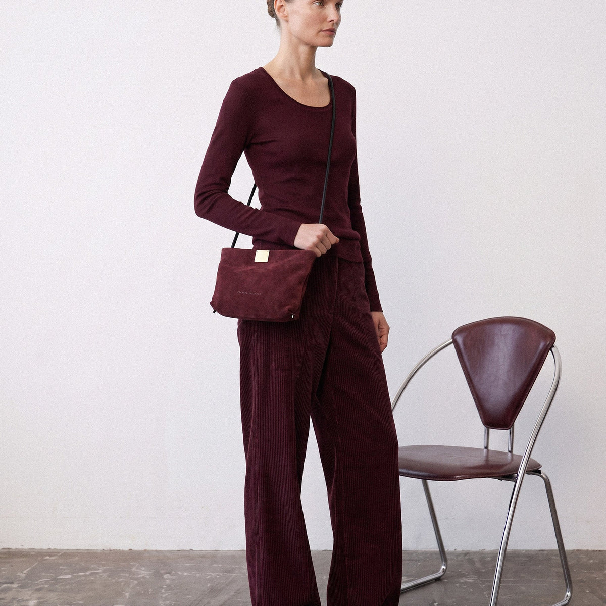 אישה בלוק טונאלי בגווני יין עם Capri Clutch בצבע Bordeaux, תיק זמש בורדו