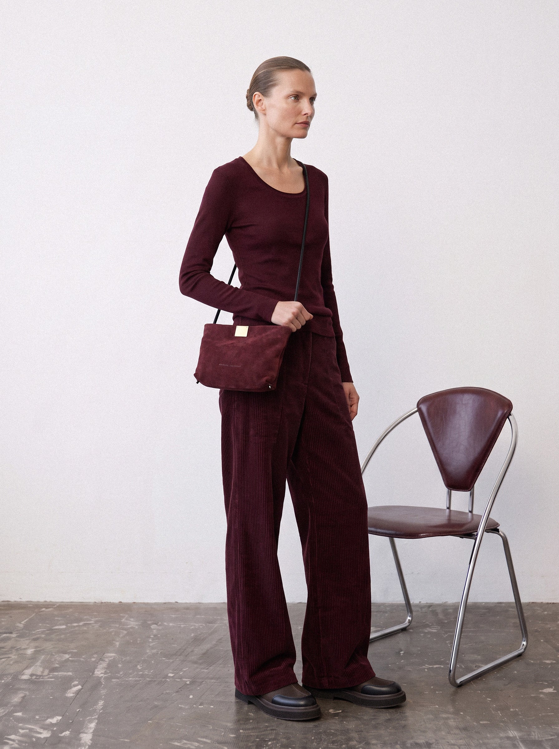אישה בלוק טונאלי בגווני יין עם Capri Clutch בצבע Bordeaux, תיק זמש בורדו